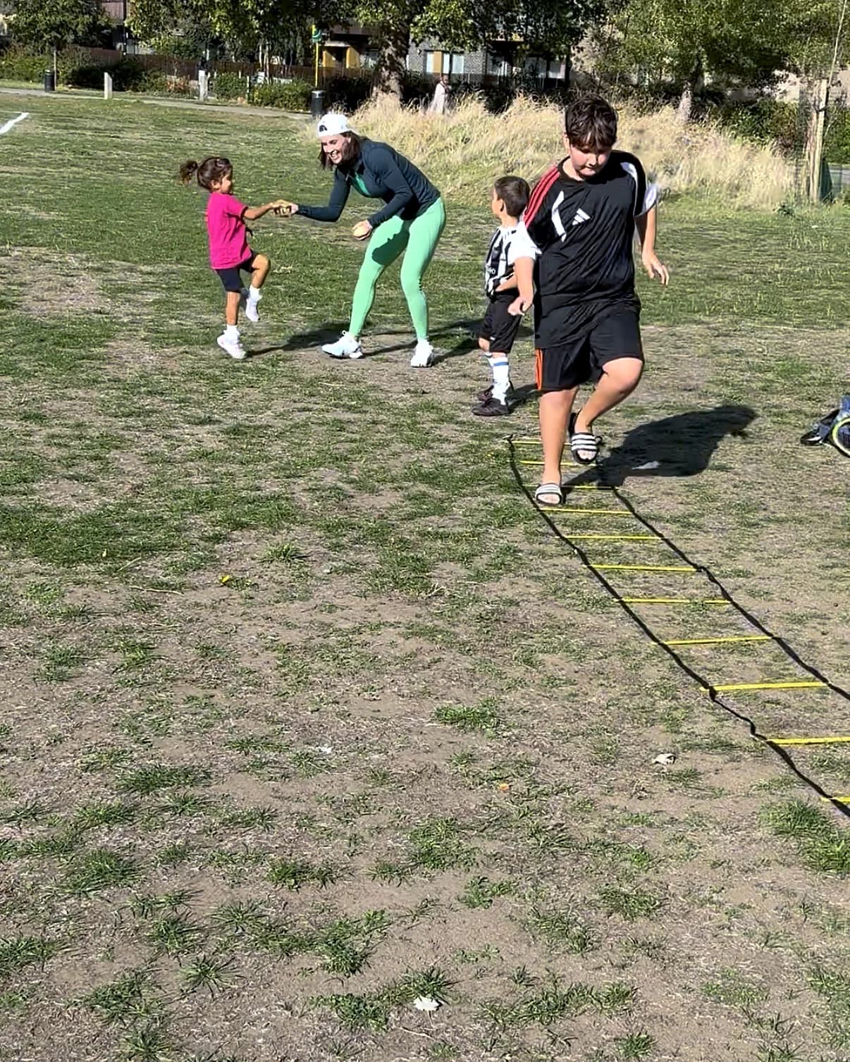 Vanessa and a group of children moving around the ladder and cones