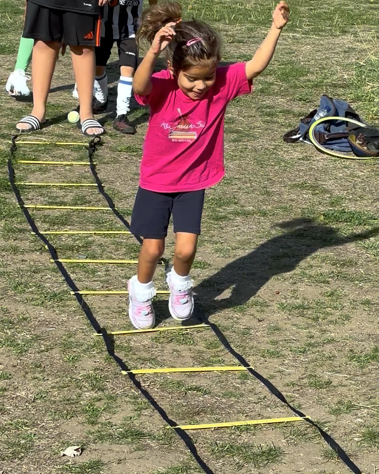 A child jumping through the agility ladder