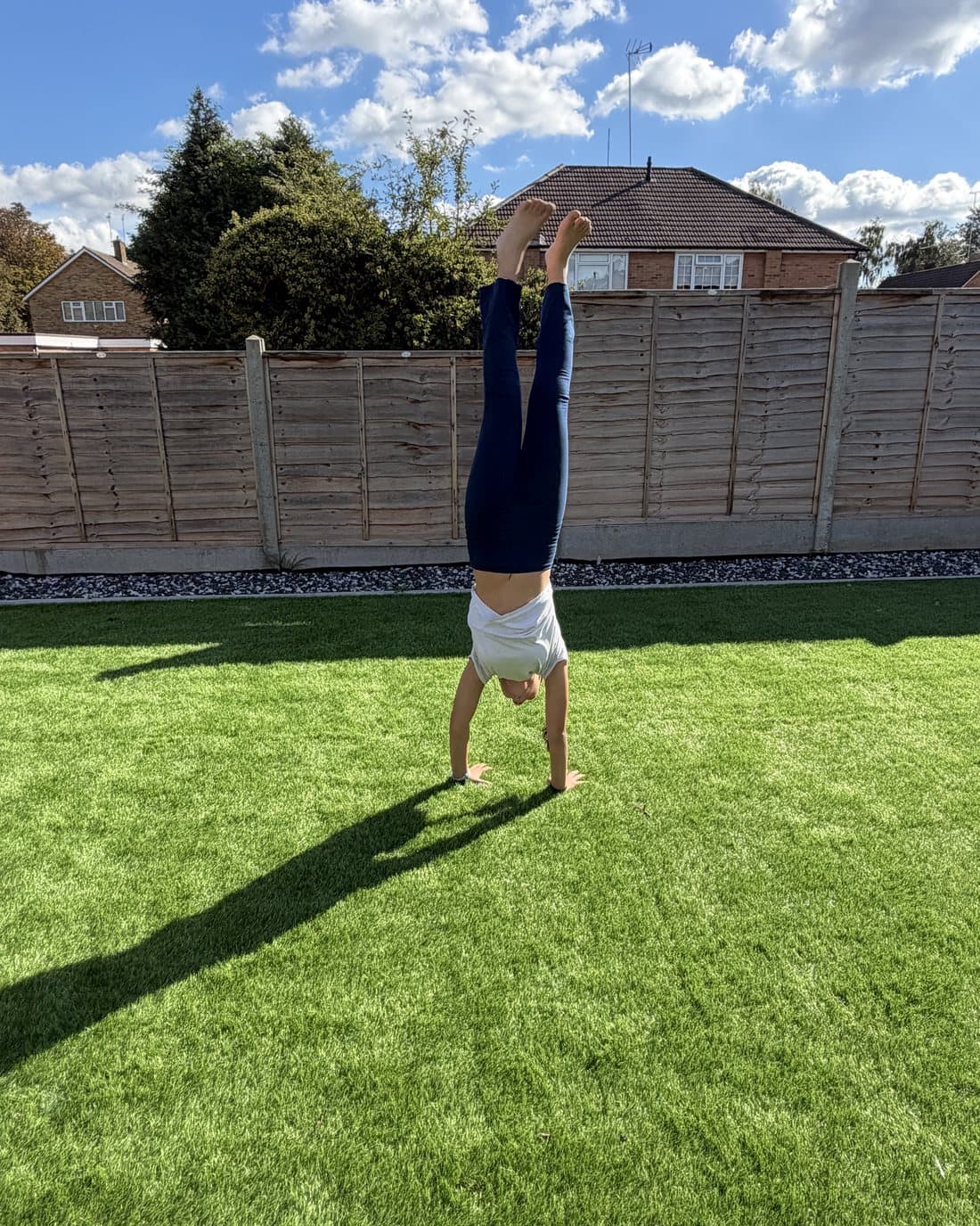 A child holding a handstand on the grass